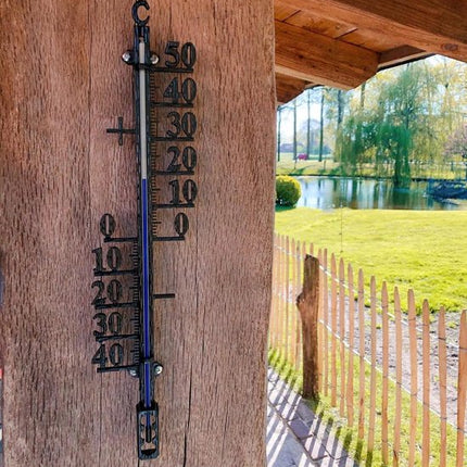 Buitenthermometer op houten paal met uitzicht
