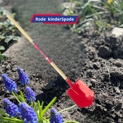 Rode kinderschop in tuin met bloemen